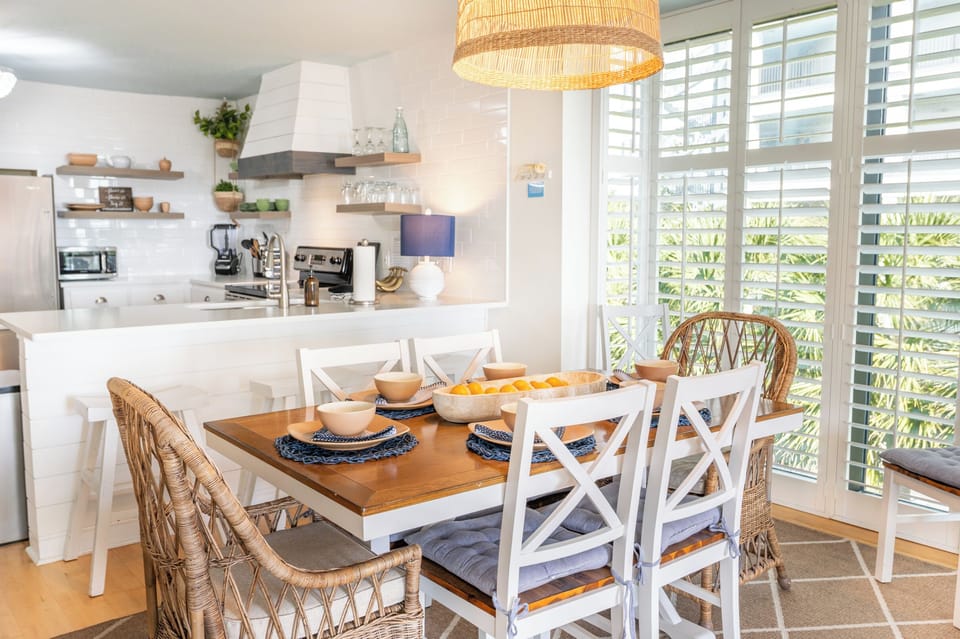 Coastal‑bright kitchen and dining space with natural textures, fresh light, and a relaxed seaside feel.