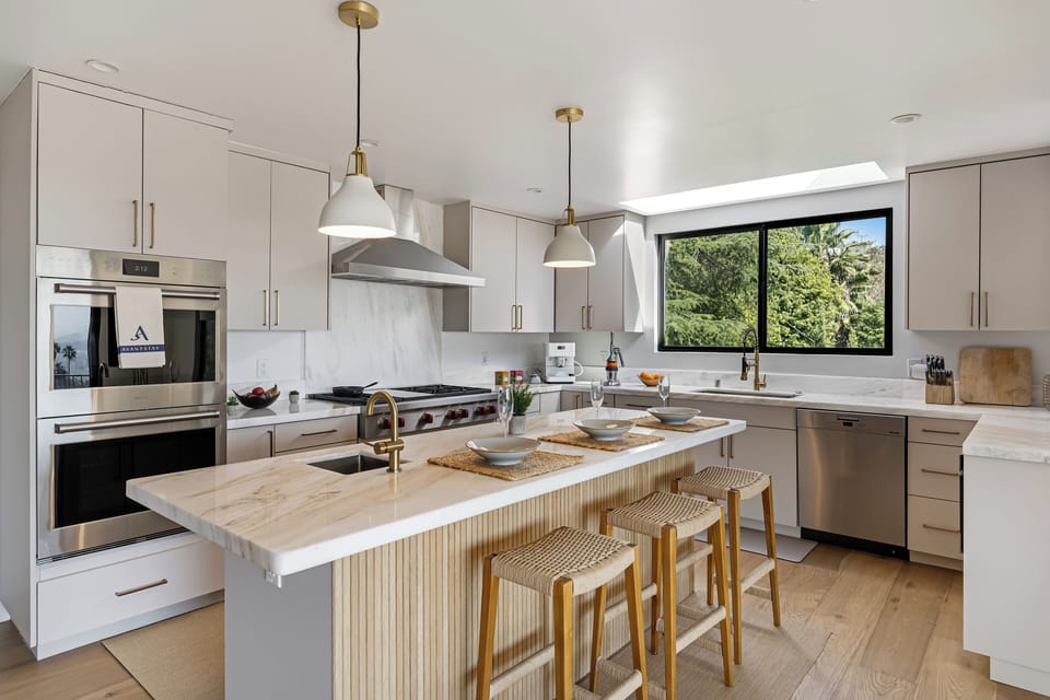 A bright designer kitchen with premium appliances, marble finishes, and a spacious island for gathering.