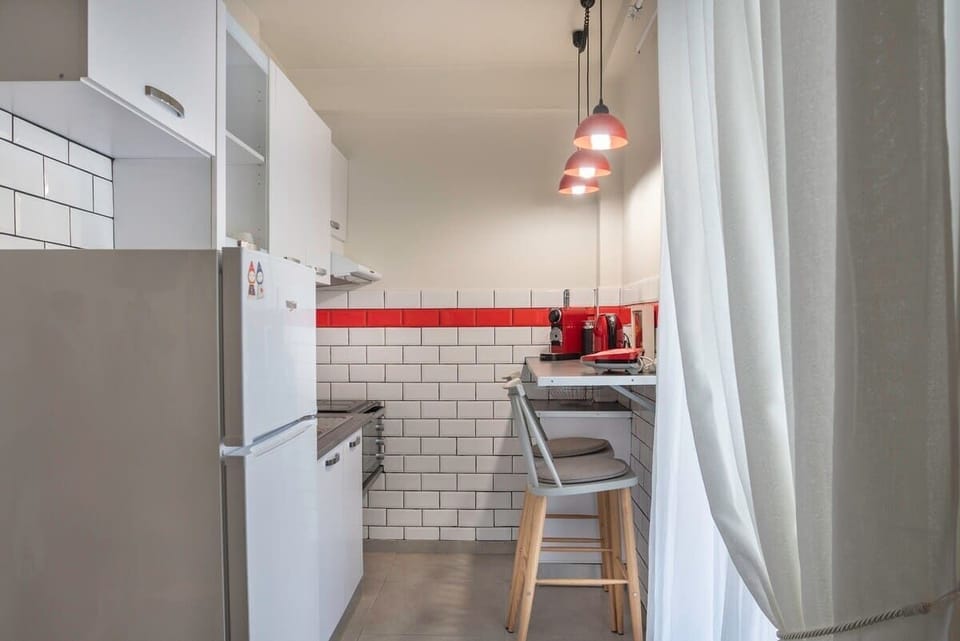 Compact and fully equipped kitchen with modern appliances and bold red accents.