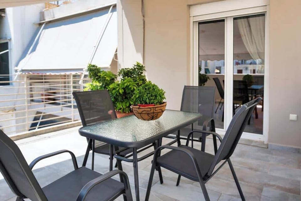Sun-drenched private terrace with outdoor seating — the ideal spot for your morning coffee with Athens as your backdrop.