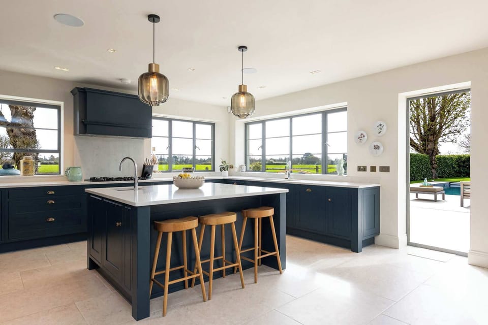 Modern kitchen with large central island, high-spec appliances, and beautiful countryside views throughout.