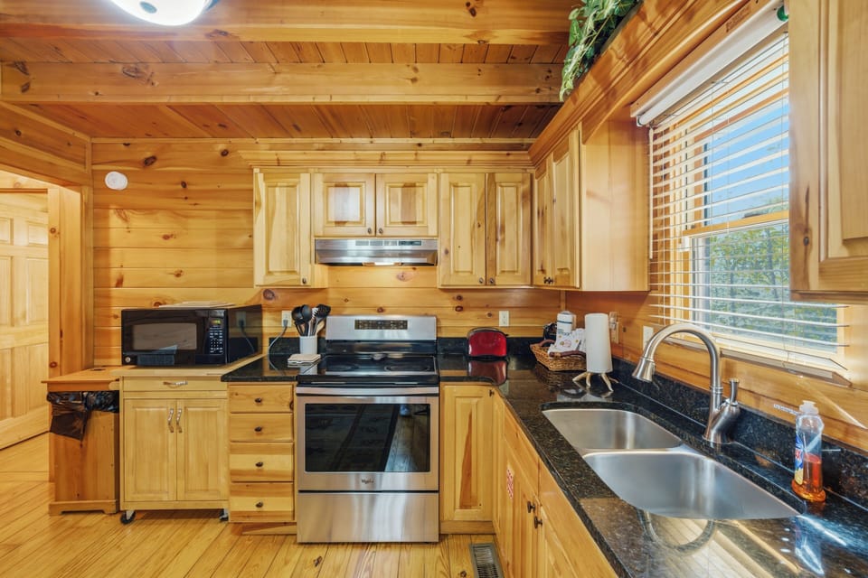 Your fully-equipped rustic kitchen awaits with warm wood charm, modern appliances, and mountain views for memorable meal prep.