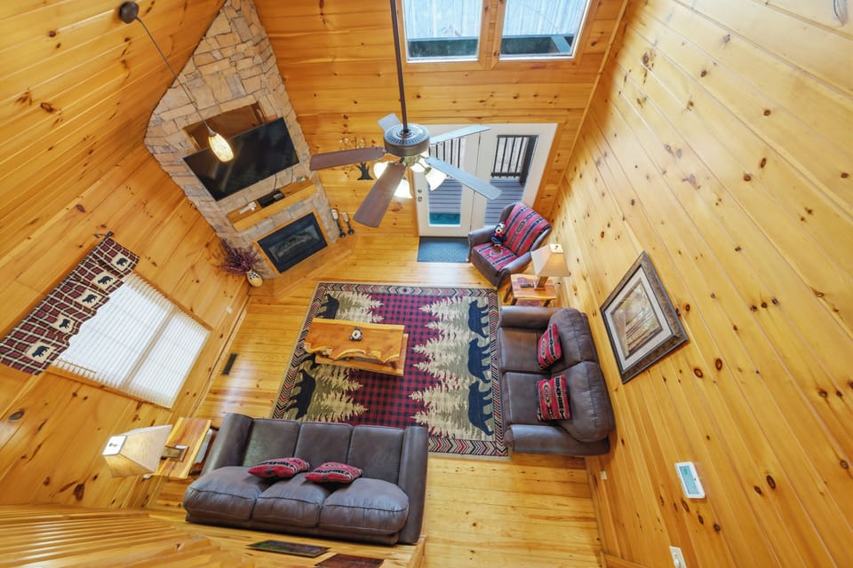 Your cozy mountain retreat features warm wood walls, a crackling stone fireplace, and rustic furnishings perfect for relaxing after outdoor adventures.