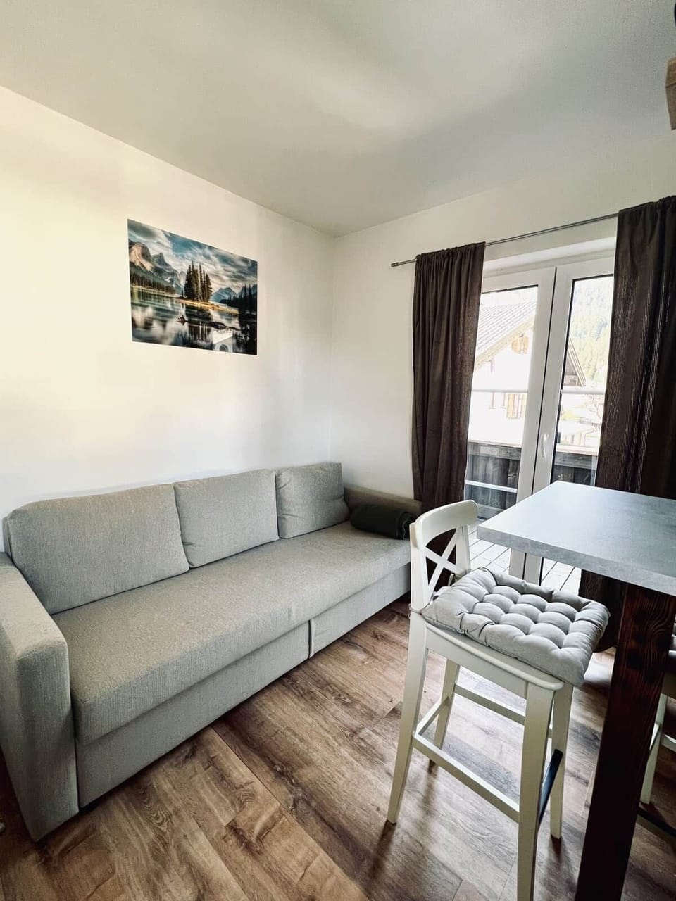 "Heller Wohnbereich mit Wohlfühlgarantie: Entspannen Sie auf dem großzügigen Sofa mit direktem Zugang zum Sonnenbalkon."