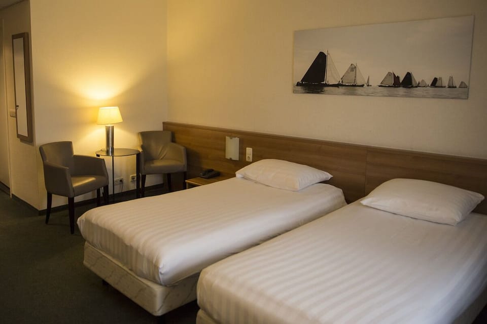 Unwind in a calm twin room with warm lighting.