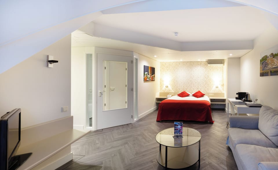 Unwind in a spacious suite with lounge seating and plush bed.