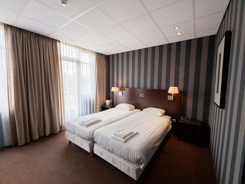 Unwind in a cozy twin room with soft bedside lighting.