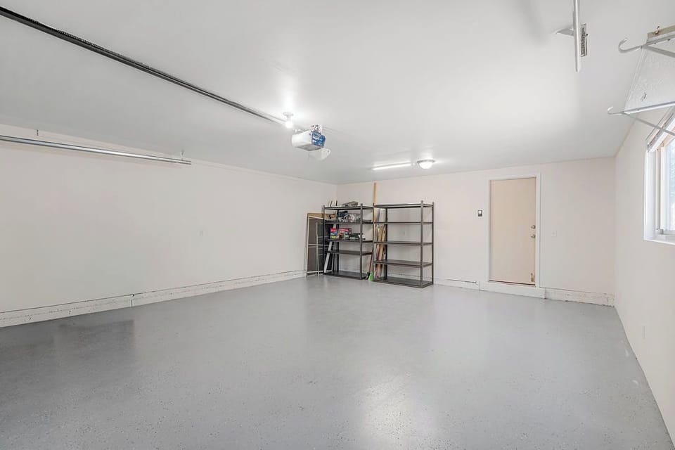 Spacious garage with convenient storage shelving and automatic door opener for your rental car and gear.