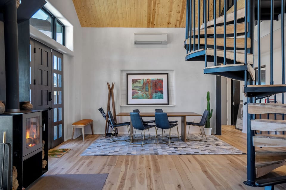 Gather around your dining table in this stunning loft space, where soaring wood ceilings and spiral stairs create architectural drama.