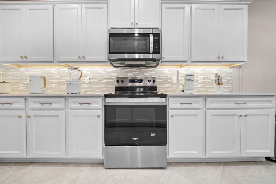 Step into this well-appointed kitchen featuring sleek stainless steel appliances and crisp white cabinetry that creates a bright, airy atmosphere. The elegant backsplash adds a touch of sophistication, making meal prep a delight.