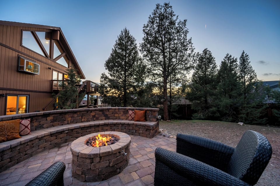 Gather around the fire pit as twilight paints the sky, creating perfect moments for evening conversations in this peaceful outdoor retreat.