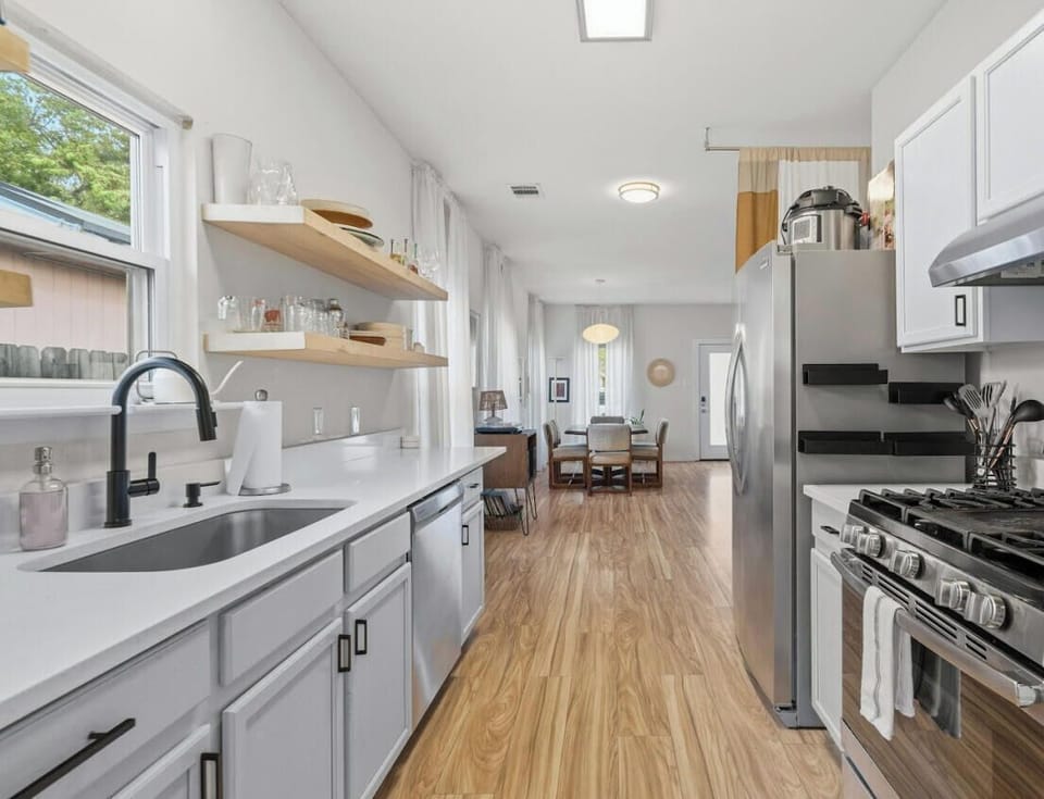 Cook a full meal in the well-equipped kitchen with gas range, farmhouse sink, and open shelving for easy access.