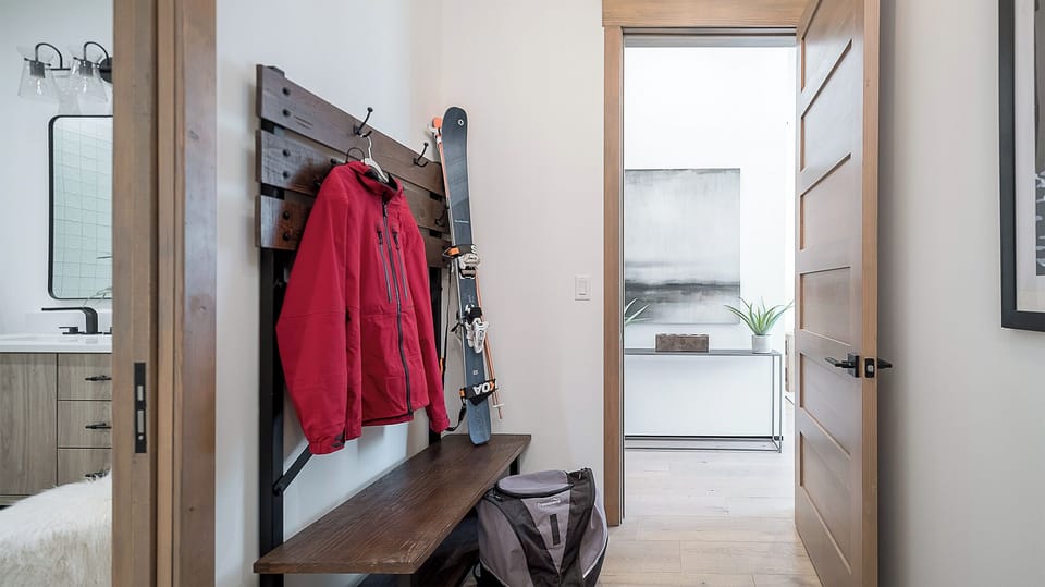 Lower Level - A hallway area with wall hooks and bench for storage