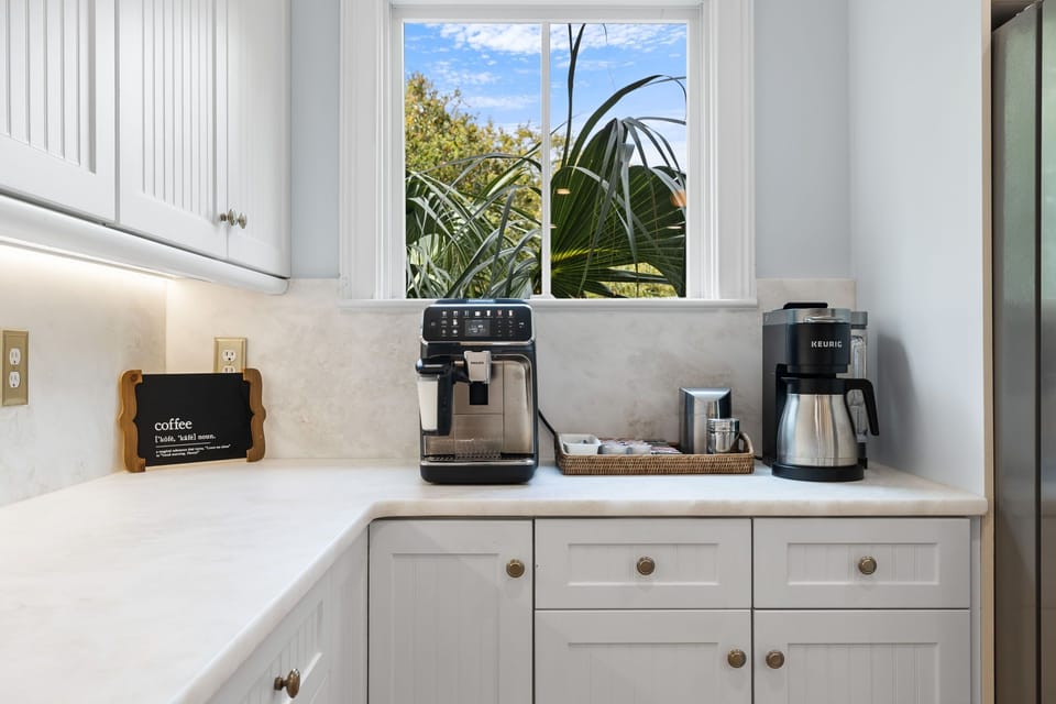 Start your mornings right with a premium coffee station featuring professional espresso machine and Keurig brewer in your bright, well-equipped kitchen.
