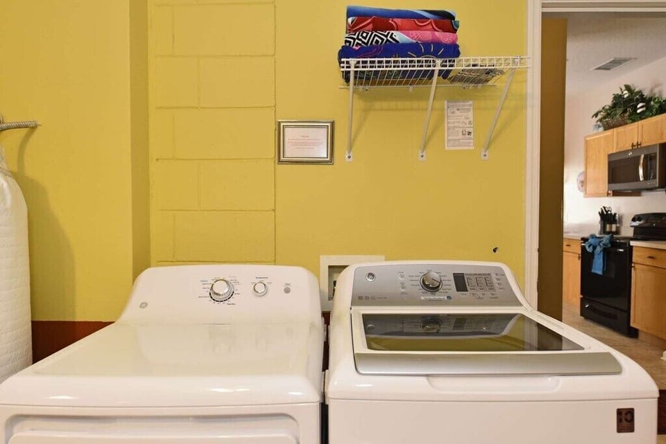 In-home laundry room with washer, dryer, and storage shelves.