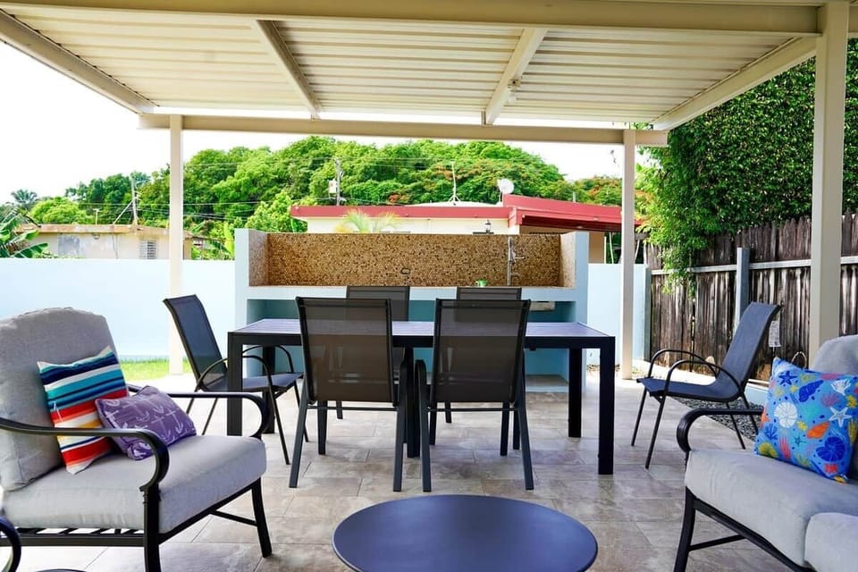 Covered terrace with dining table and seating for four. Enjoy outdoor meals surrounded by tropical greenery.