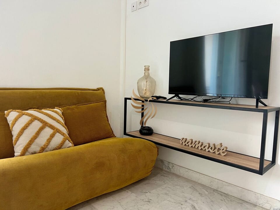 Espace détente avec canapé confortable et TV, parfait pour se relaxer après une journée en extérieur