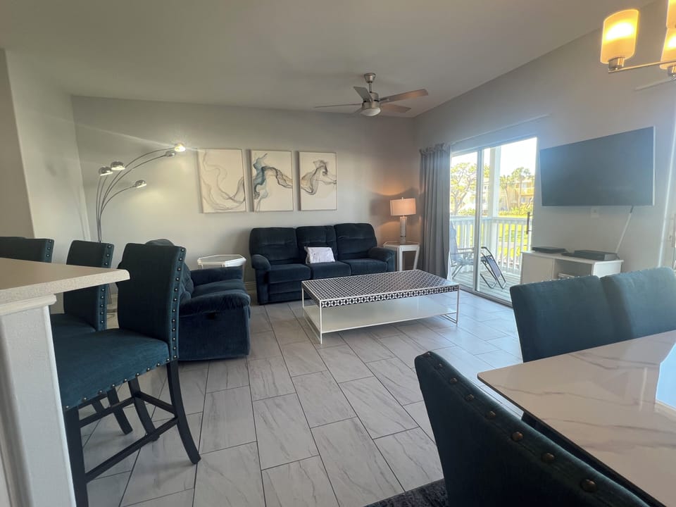 Settle into your stylish living space with plush seating, modern artwork, and natural light streaming through your private balcony doors.