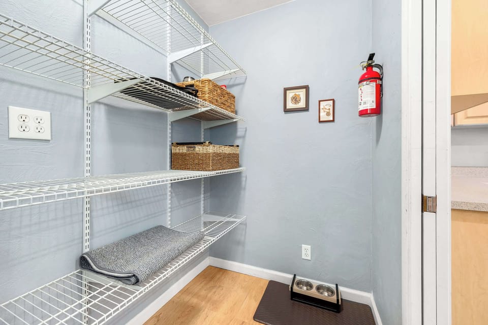 Pantry with shelving and a dog bowl for the pooches.