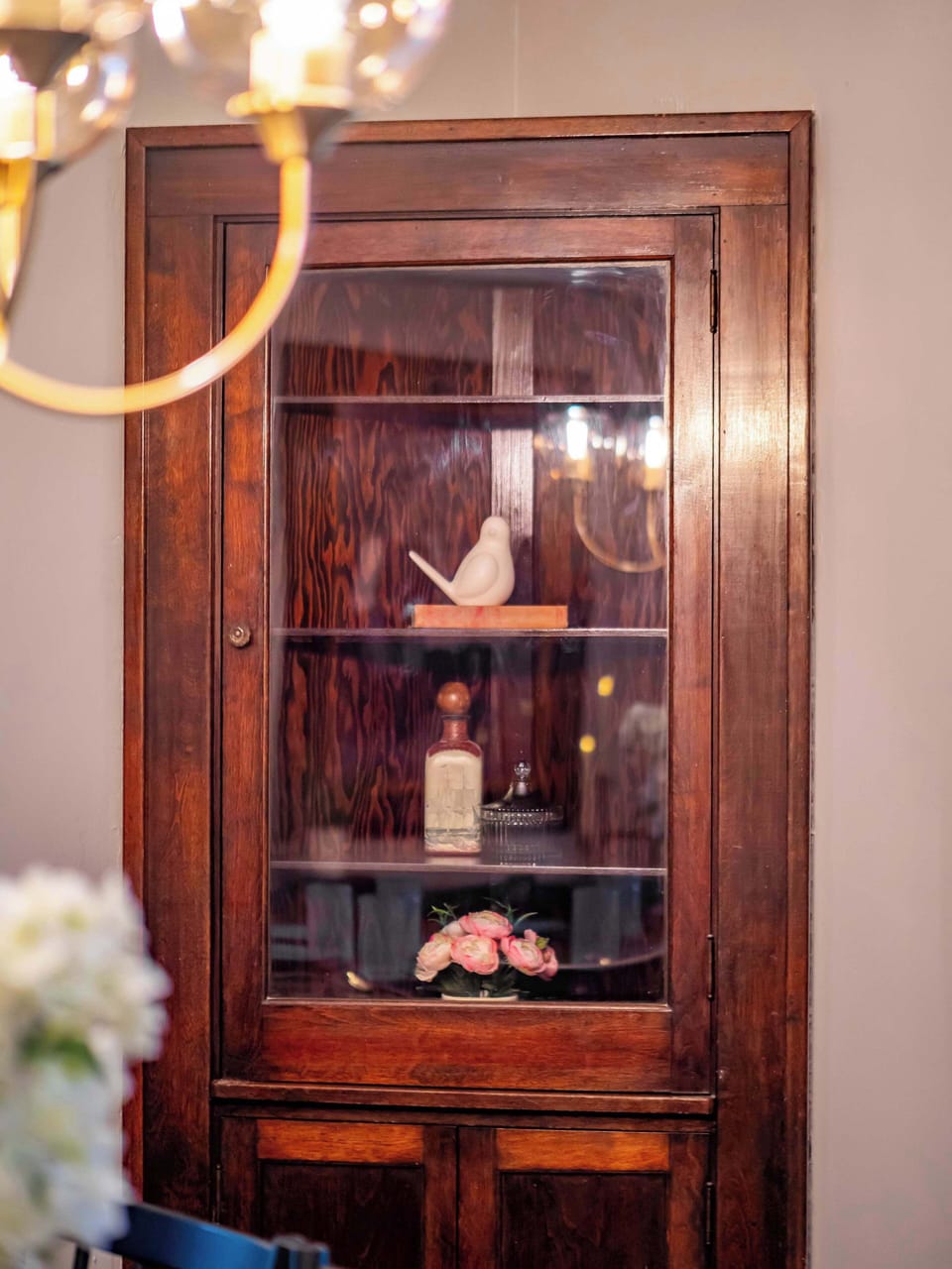 Warm wood cabinet w/ display shelving — a beautiful vintage touch in the space.

