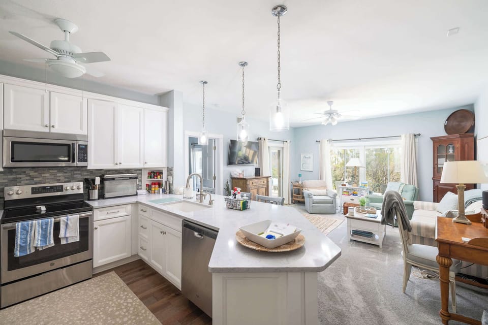 Fully equipped kitchen with spacious island seating - perfect for cooking and gathering. Open-concept layout flows into the cozy living area with plenty of natural light, creating a welcoming space for relaxing and entertaining