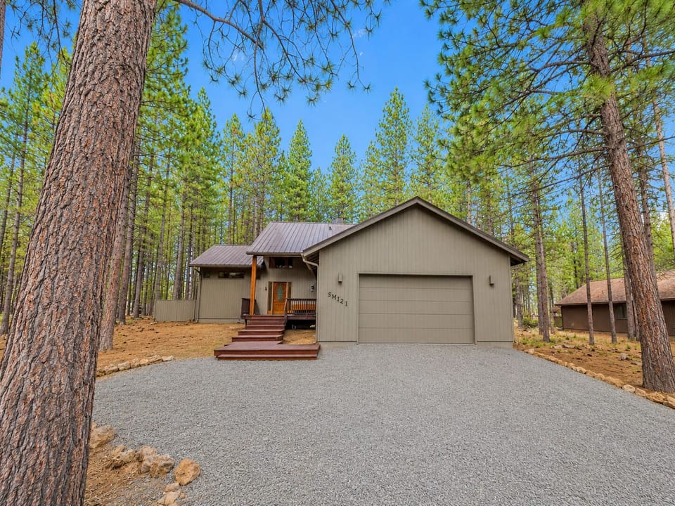Exterior front of home with covered porch sitting area and 2-car garage.