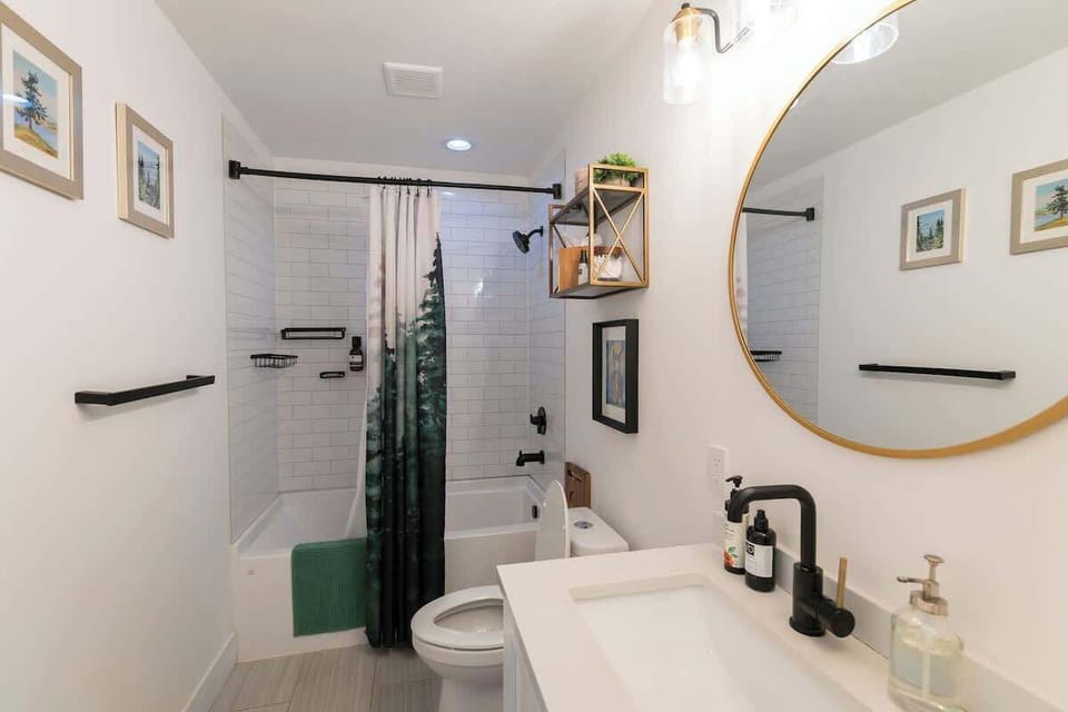 The main bathroom of the house is adjacent to the front bedroom. It features a deep soaking tub and shower combo. 
