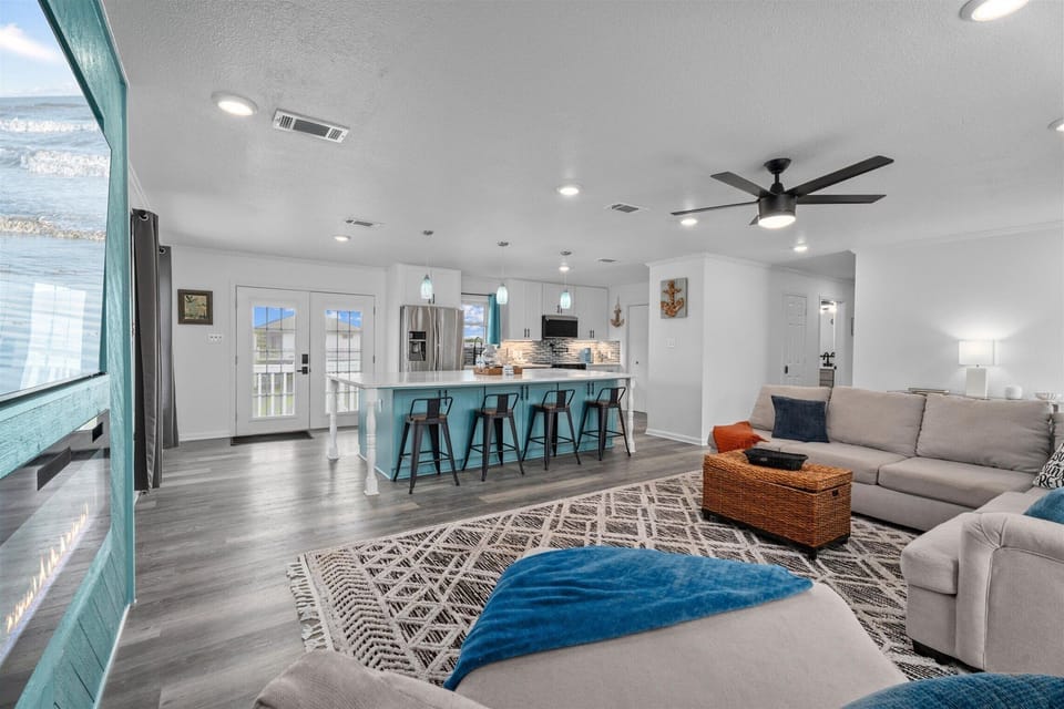 Large open-concept living room and kitchen with bar seating and modern finishes.