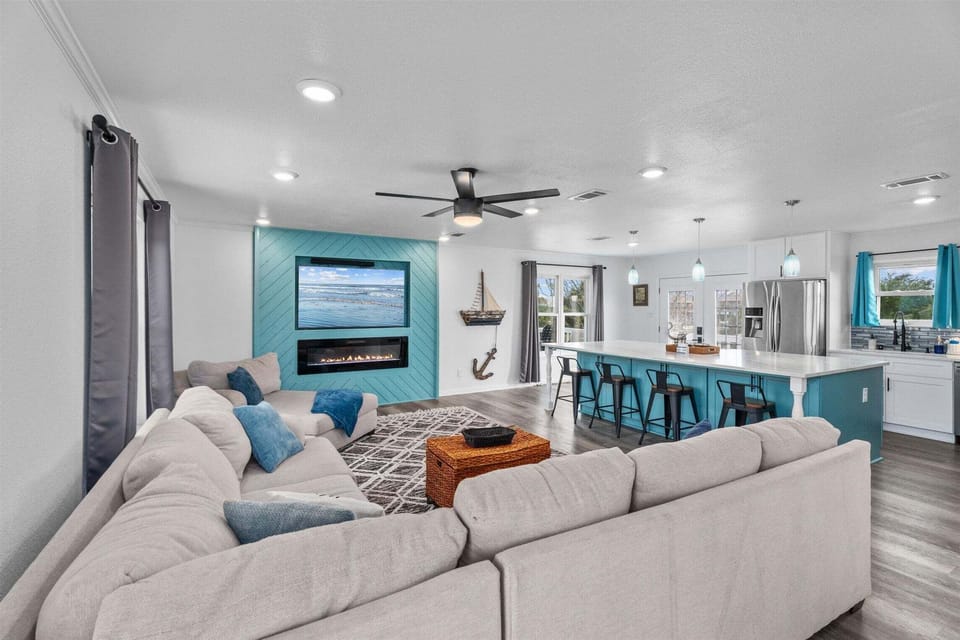 Wide living space with ample seating, TV feature wall, and modern interior design.