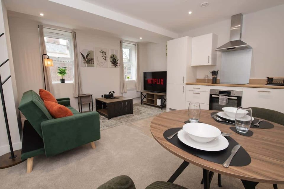 Unwind in our cozy living room featuring a smart TV for movie nights, with a spacious open-plan layout that flows seamlessly into the kitchen and dining area.