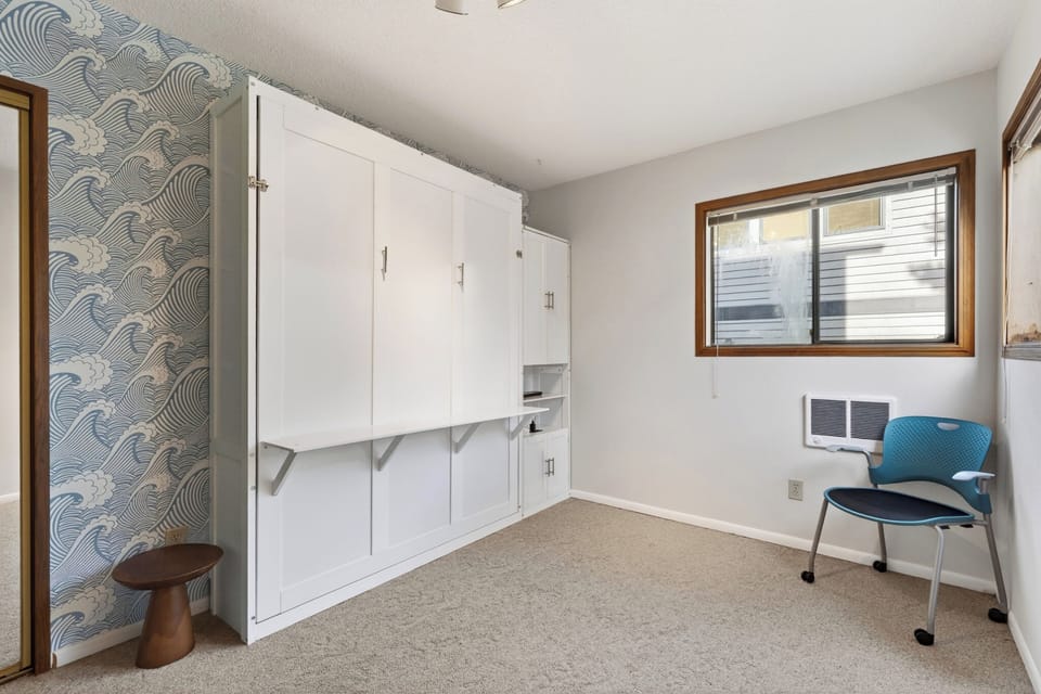Showing the bedroom with the Murphy bed tucked away to save space.