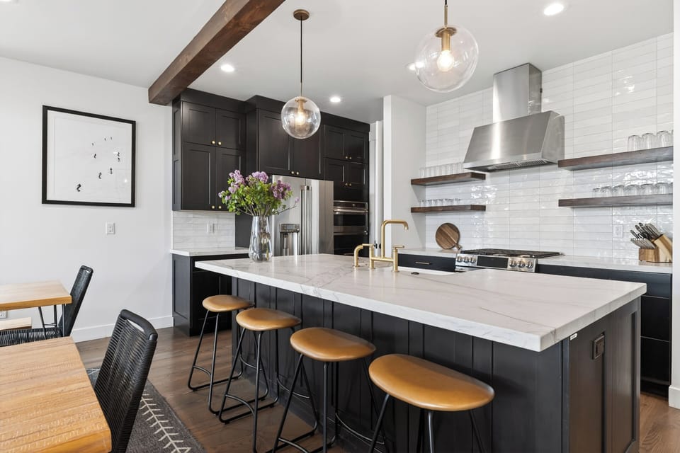 Sleek modern kitchen with a marble island, warm wood accents, and elegant brass details.
