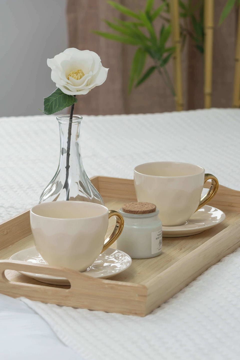 A decorative tray with a cup, a small vase with flowers, and subtle accessories. The arrangement creates a calm, welcoming atmosphere. Light tones and natural elements add a touch of elegance.