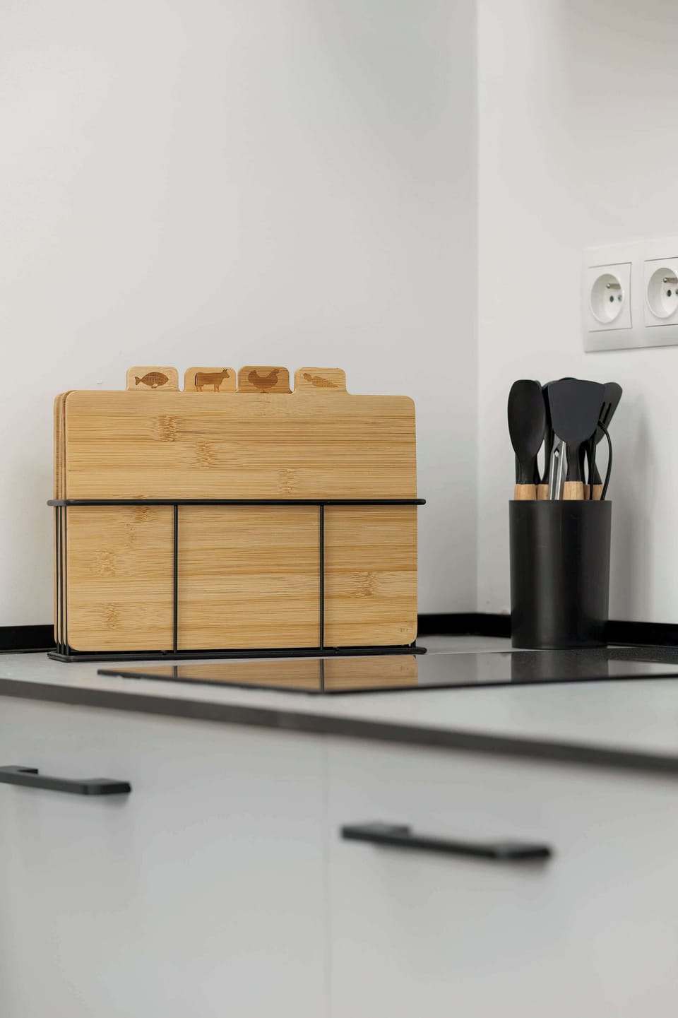A kitchen countertop with a wooden box and basic cooking utensils. The setup is practical yet visually pleasing, keeping everything within easy reach. Neutral colors maintain a cohesive design.