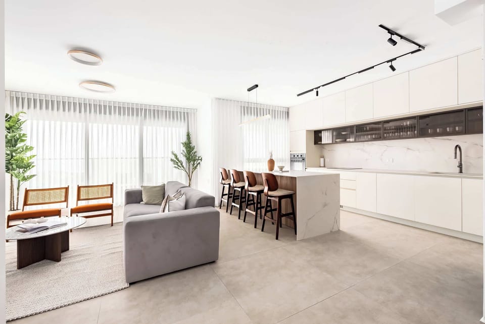 Bright modern apartment with open kitchen, cozy seating, natural light, and minimalist design throughout feel