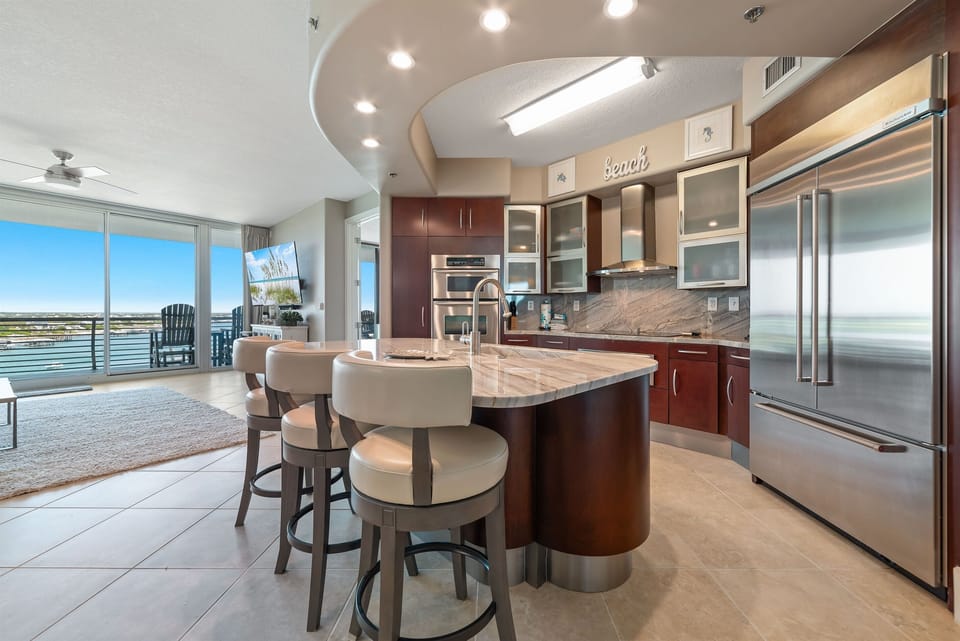 The modern kitchen island with bar seating offers a casual dining option, while the open layout maximizes natural light and showcases the stylish finishes throughout.