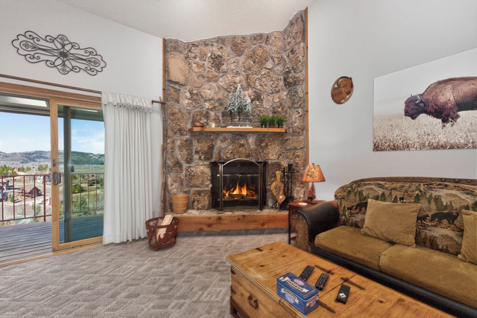 Cozy up by your crackling stone fireplace while taking in mountain views from your private balcony—perfect for unwinding after adventure-filled days.