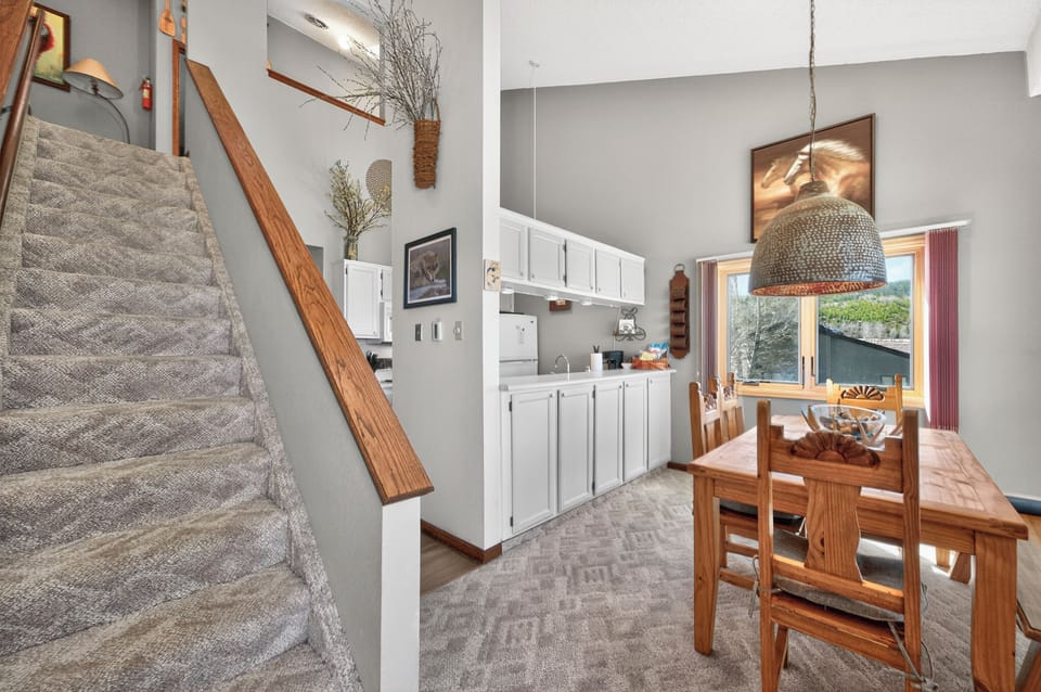 Relax in your open-concept living space where warm wood tones meet modern comfort. The full kitchen and cozy dining area create perfect gathering spots.