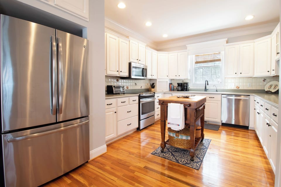 Cook your favorite meals in this spacious gourmet kitchen featuring stainless steel appliances, ample counter space, and a charming wooden island perfect for meal prep.