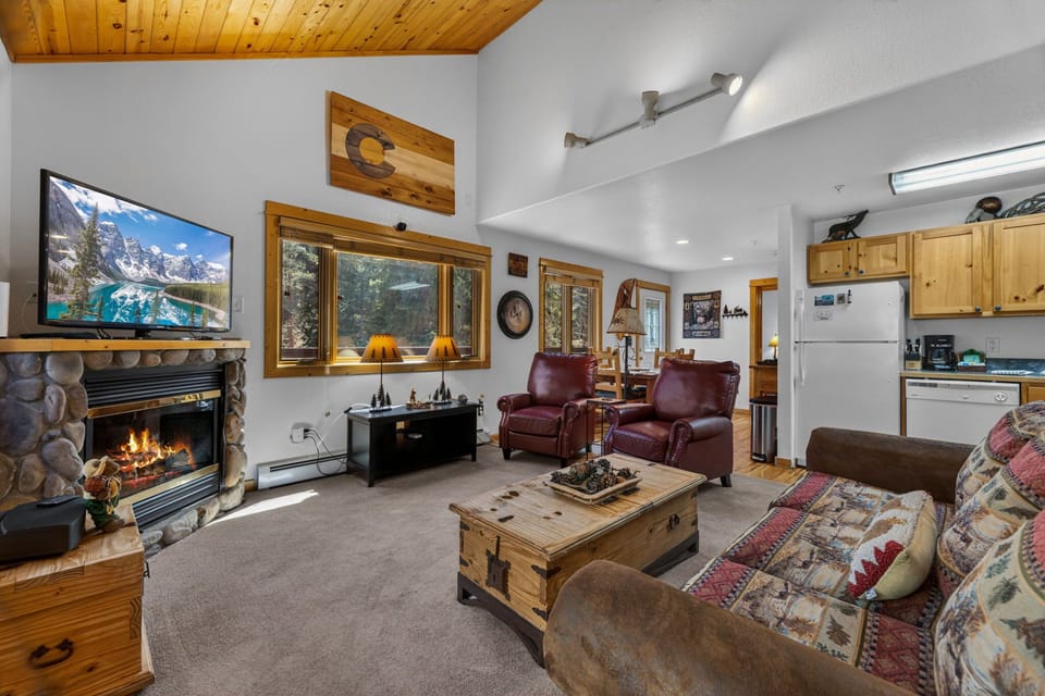 Cozy up in your mountain retreat with crackling fireplace, leather chairs, and rustic charm throughout this inviting living space.