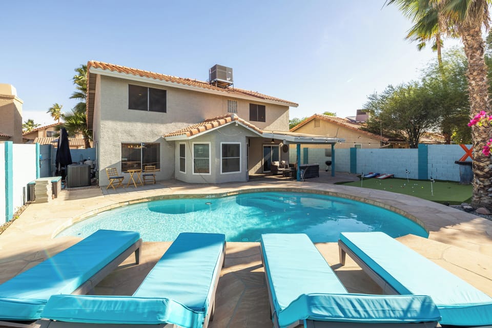 Spacious backyard with sparkling pool and sun loungers