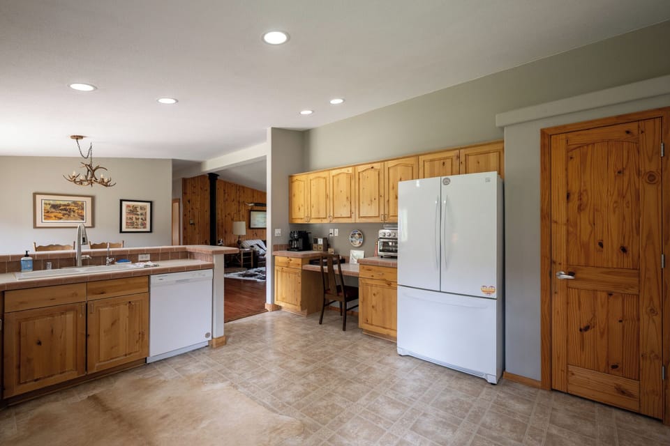 Your spacious kitchen with rustic pine cabinetry, modern appliances, and open layout invites meal prep and gathering with loved ones.