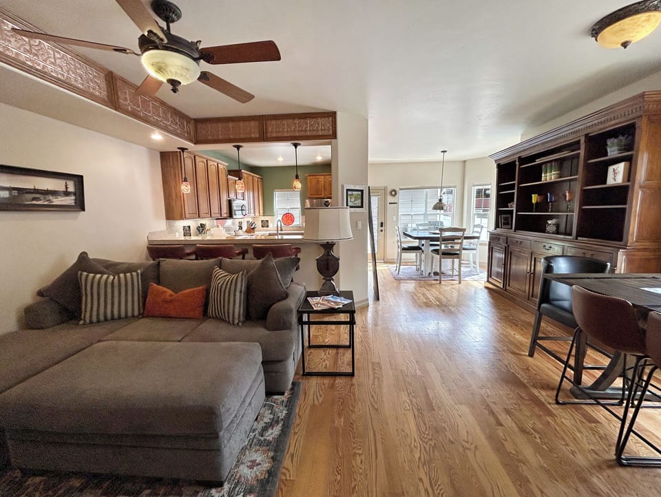 Relax in your spacious open-concept living area where warm wood floors flow from cozy seating to a fully equipped kitchen.