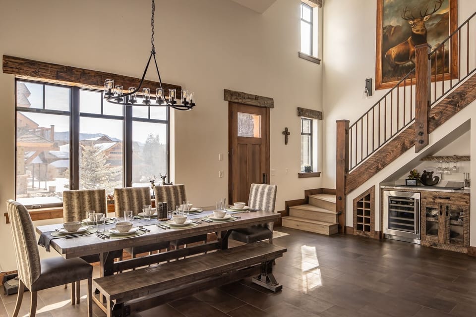 Gather around this stunning rustic dining table where memorable meals and conversations await beneath the elegant chandelier's warm glow.