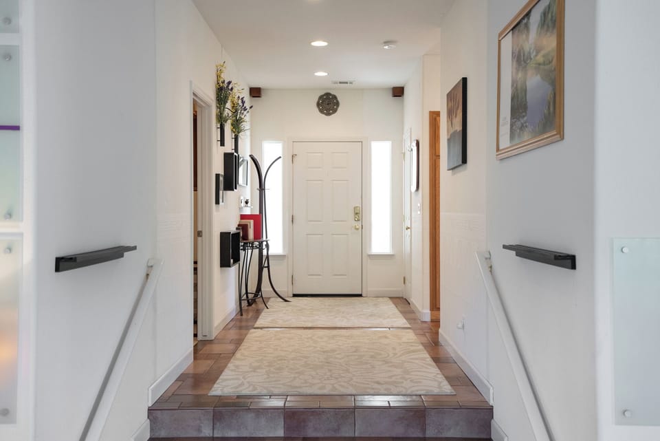 This welcoming home entryway features a classic white front door flanked by sidelight windows that bathe the space in natural light.