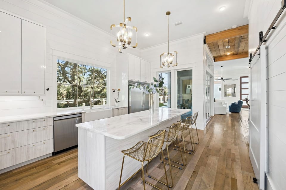 Cook and connect in your bright, modern kitchen featuring marble countertops, premium appliances, and a spacious island perfect for morning coffee.