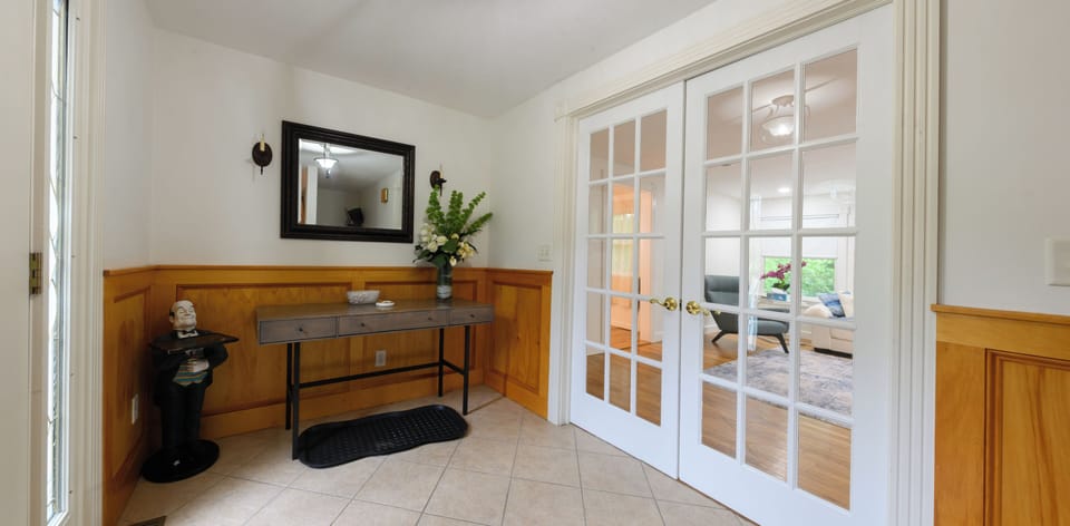 Bright, welcoming entry with elegant French doors and stylish decor