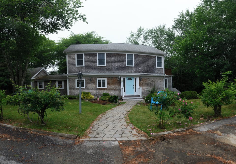 Charming tree-lined home with lush yard and inviting front entry