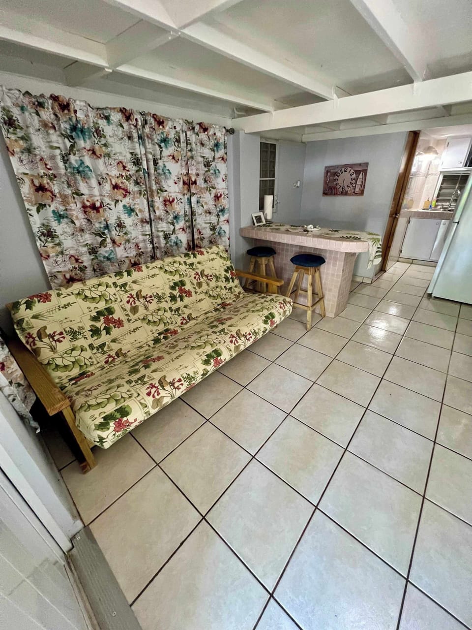 Cozy living area with floral sofa and open access to the kitchen.
