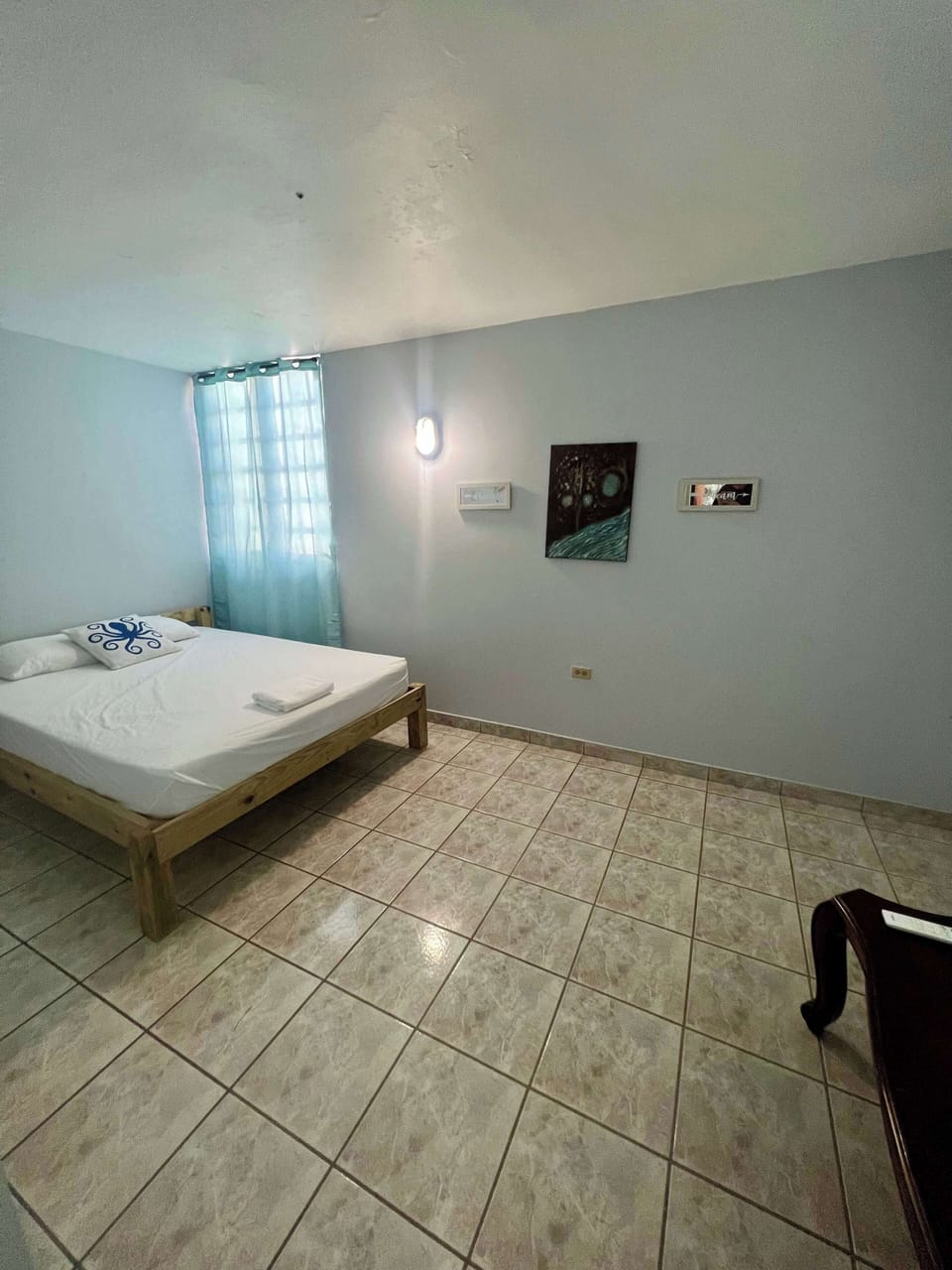 Airy bedroom with tiled floors and natural light from the window